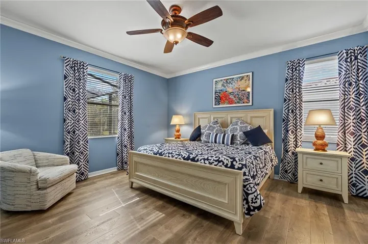 Bedroom with hardwood / wood-style floors, ceiling fan, and ornamental molding