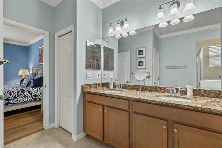 Bathroom featuring hardwood / wood-style flooring, vanity, an enclosed shower, and ornamental molding