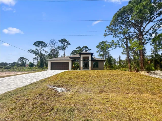View of front of house featuring a garage and a front yard