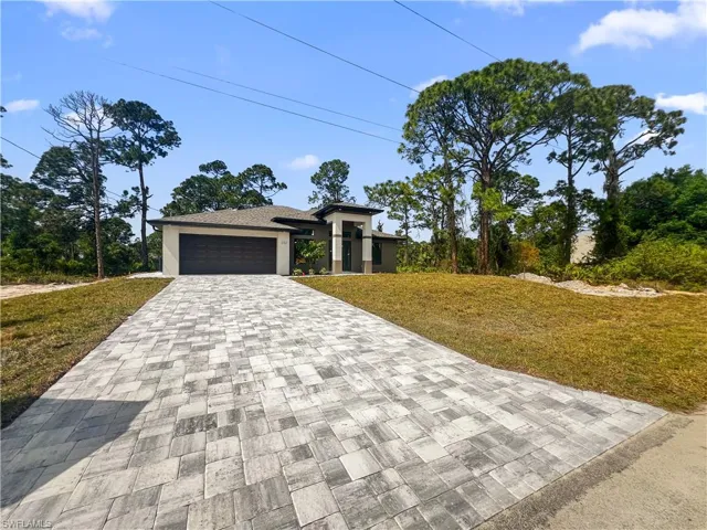 View of front of house with a front yard and a garage