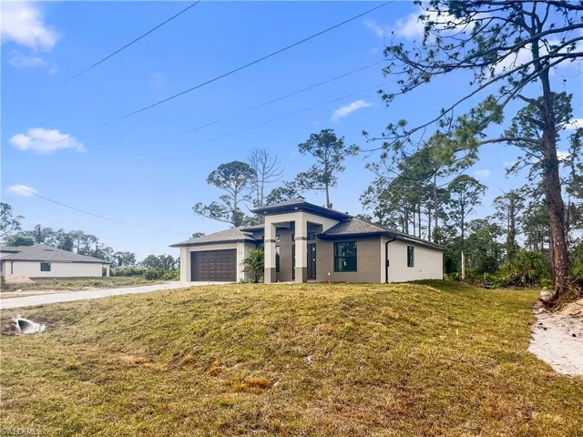 View of front of home featuring a garage and a front yard