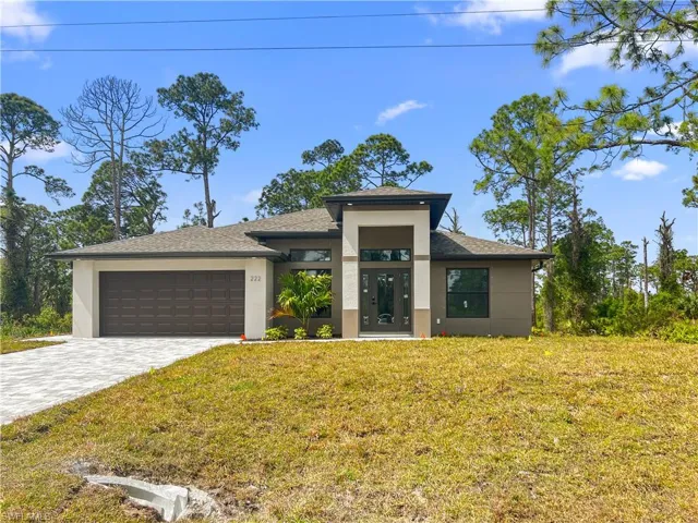 View of front of home with a front lawn and a garage