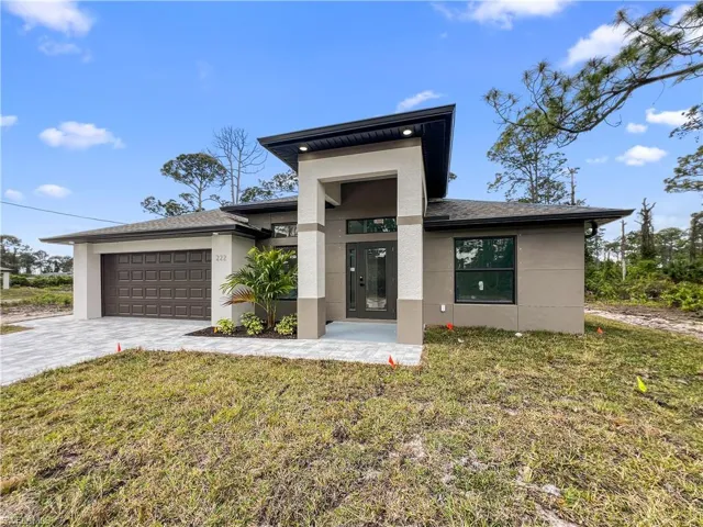View of front facade with a front lawn and a garage