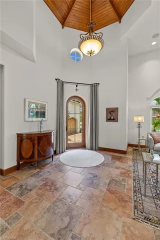 Entryway with high vaulted ceiling and wood ceiling