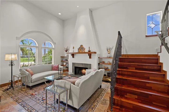 Living room with a high ceiling, tile flooring, and a fireplace