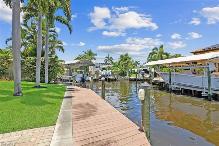 View of dock featuring a water view and a lawn