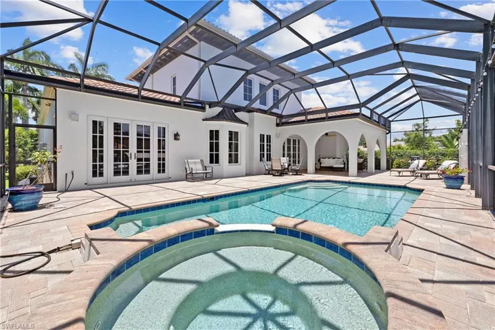 View of swimming pool featuring a patio area, french doors, screen enclosure, and an in ground hot tub