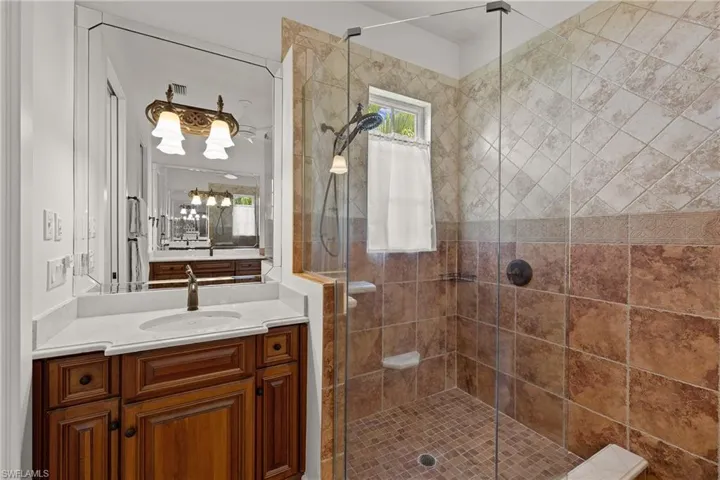Bathroom featuring a shower with door and vanity
