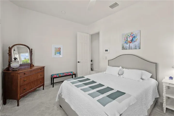 Bedroom featuring light new carpet and Minka ceiling fan