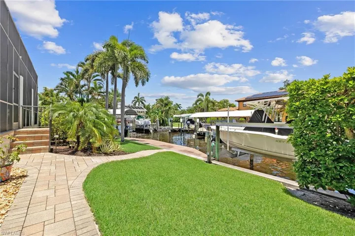 View of yard with a canal water view and a dock