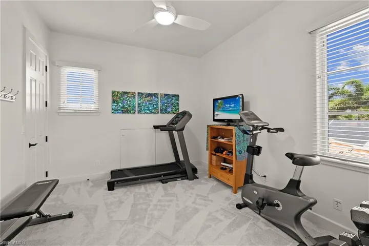Exercise room with new carpet flooring and ceiling fan