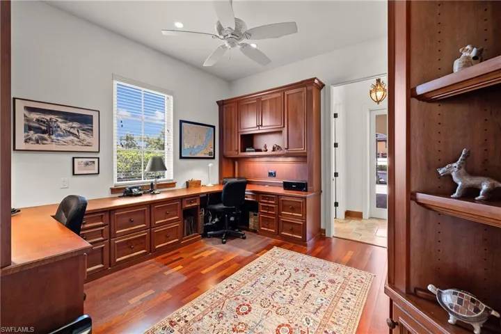 Office featuring built in desk, ceiling fan, and Brazilian Cherry flooring
