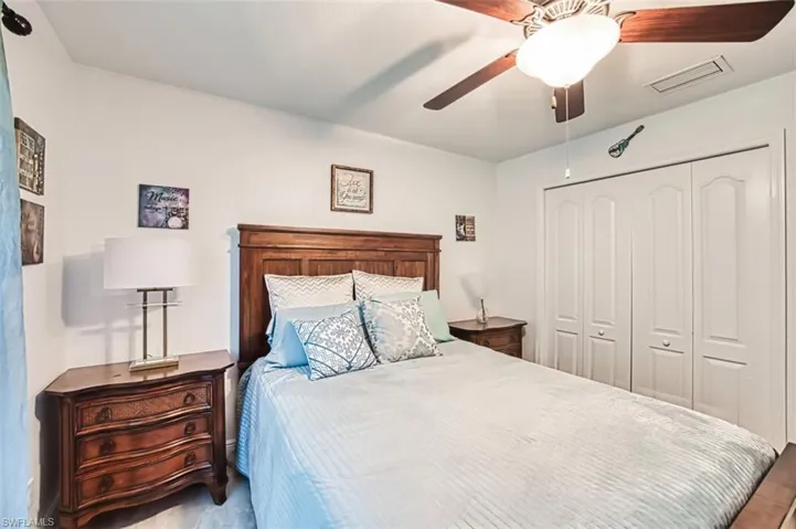 Bedroom featuring visible vents, ceiling fan, wood finished floors, and a closet