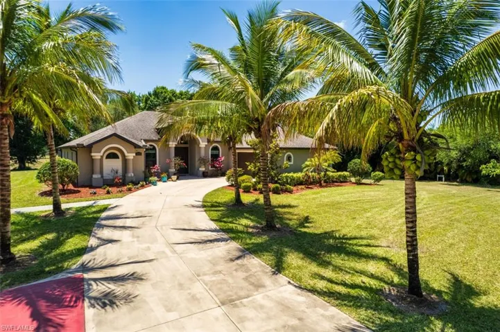 View of front of home featuring concrete driveway, a garage, a front yard, and stucco siding