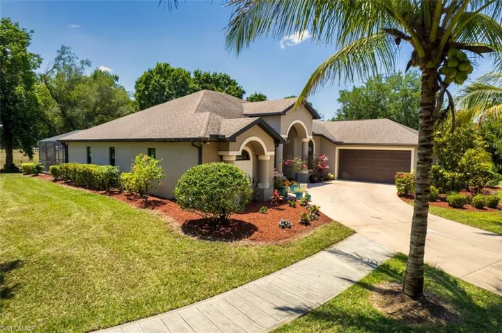 Single story home with a shingled roof, a garage, stucco siding, a front yard, and driveway