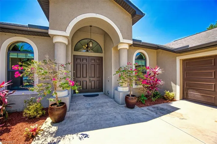 View of exterior entry with driveway and stucco siding