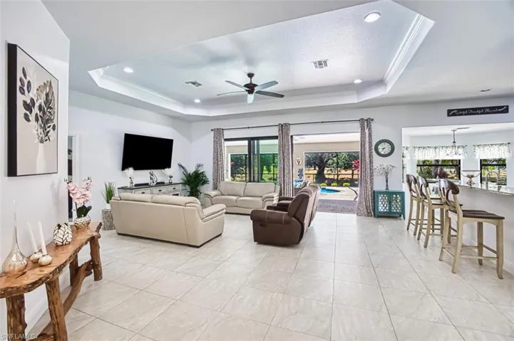 Living room with a healthy amount of sunlight, a raised ceiling, and visible vents