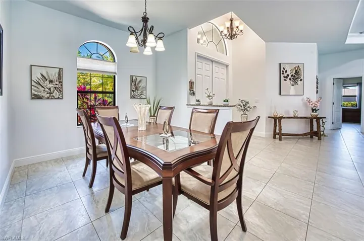 Dining space featuring light tile patterned floors, baseboards, and a chandelier