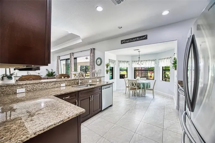 Kitchen featuring light stone countertops, dark brown cabinets, recessed lighting, a sink, and stainless steel appliances