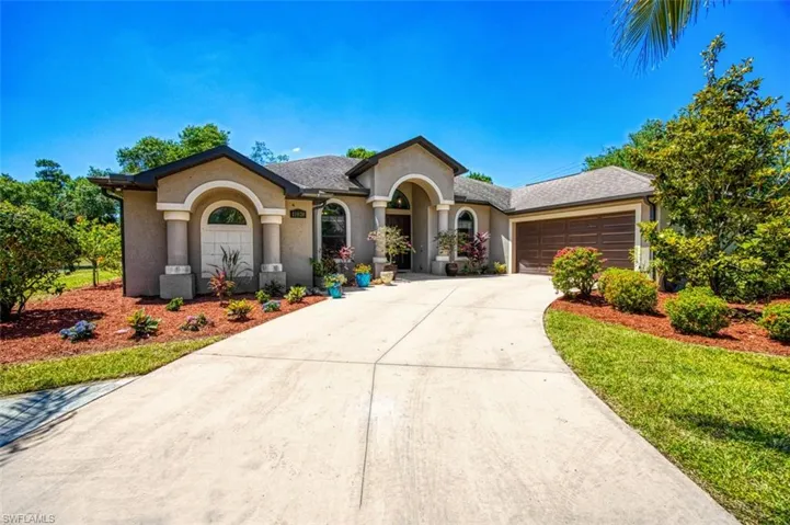 View of front facade with a garage, stucco siding, and driveway