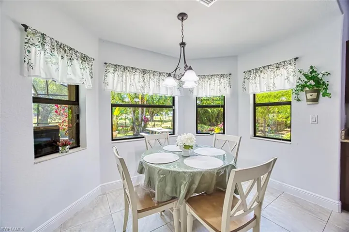 Dining space with baseboards, plenty of natural light, and a notable chandelier