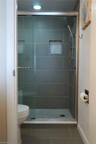 Bathroom with tile patterned floors and a stall shower