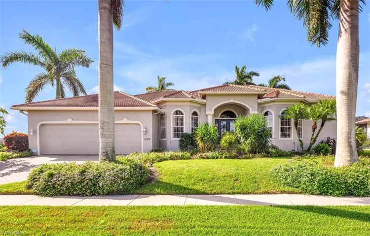 Mediterranean style home with a 3-car garage and manicured front yard with flowering shrubbery