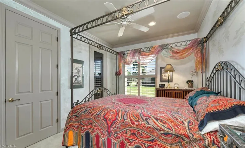 Carpeted guest bedroom with crown molding, ceiling fan and 400 bottle wine closet