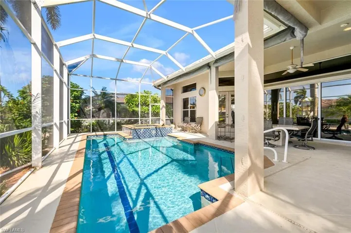 Lanai pool featuring an integrated spa, outdoor sitting area with ceiling fan