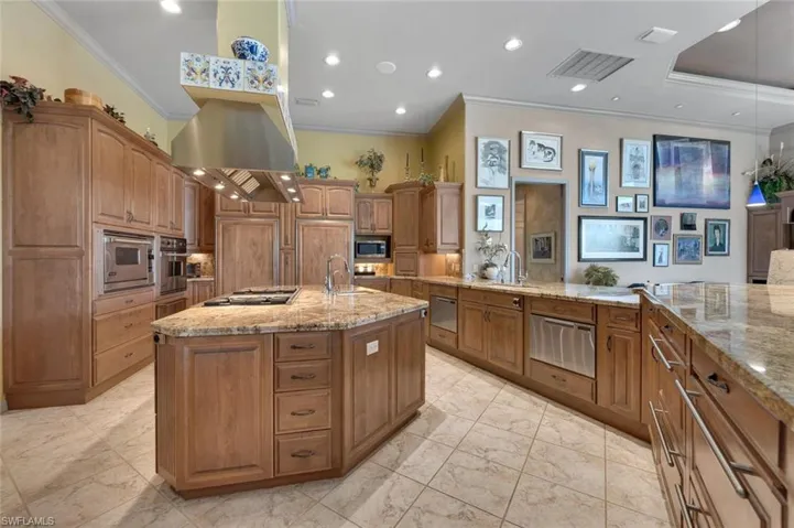 Chef's all-granite kitchen featuring island gas grill, Subzero and Viking appliances, electric and gas ovens, microwave, two dishwashers, custom maple cabinets