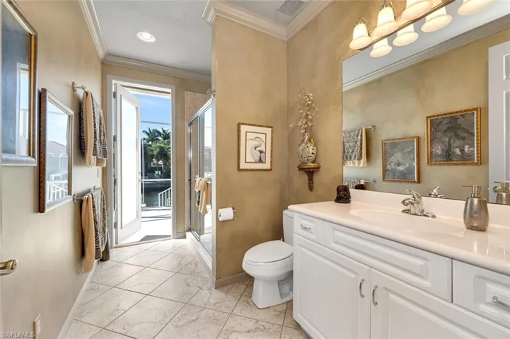 Large guest/pool bathroom featuring vanity, enclosed shower, diagonal tile flooring