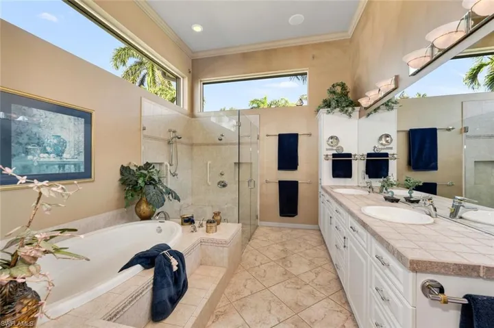 Primary bathroom featuring double vanity, soaking tub, walk in shower, toilet and bidet