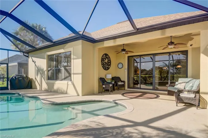View of swimming pool with ceiling fan, a lanai, and a patio