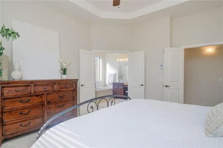 Bedroom featuring ensuite bath and ceiling fan