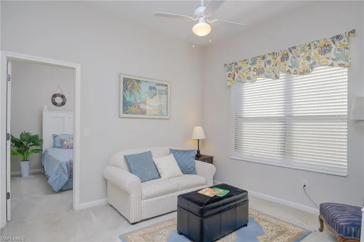 Carpeted living room featuring ceiling fan