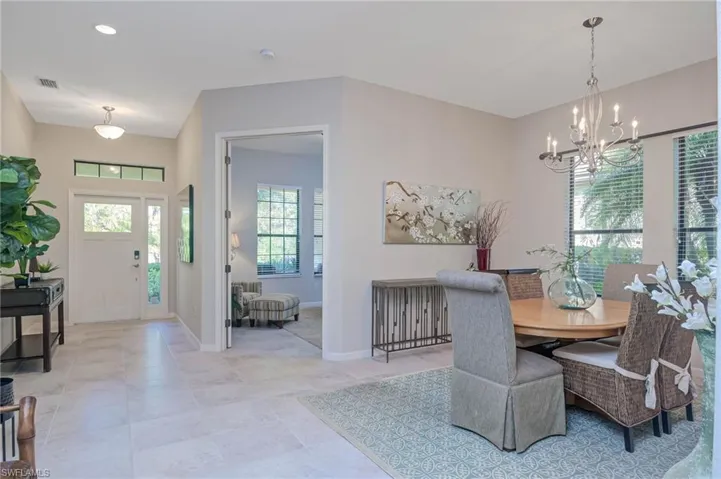 Tiled dining area with a healthy amount of sunlight and a notable chandelier