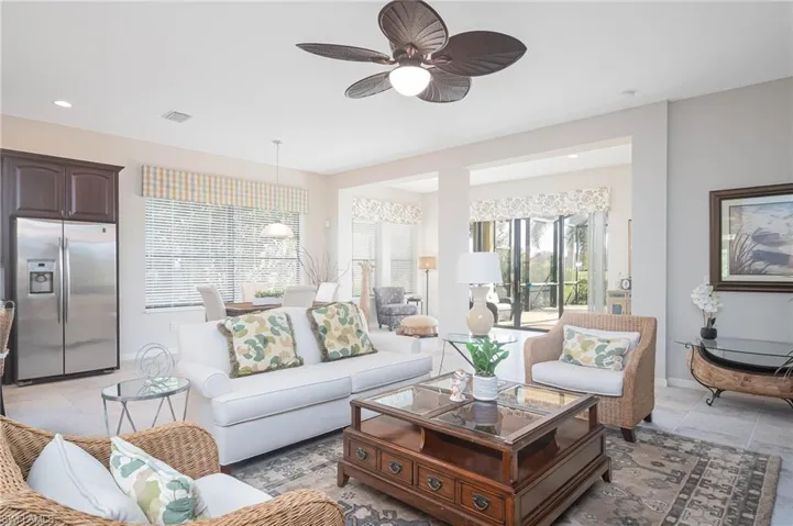 Tiled living room with plenty of natural light and ceiling fan