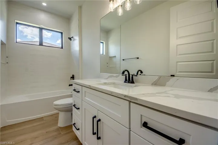 Full bath featuring vanity, light wood finished floors, and tub / shower combination