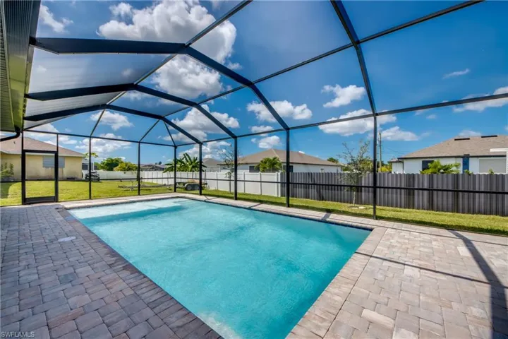 View of swimming pool featuring a sunroom, a lanai, a patio area, and a residential view