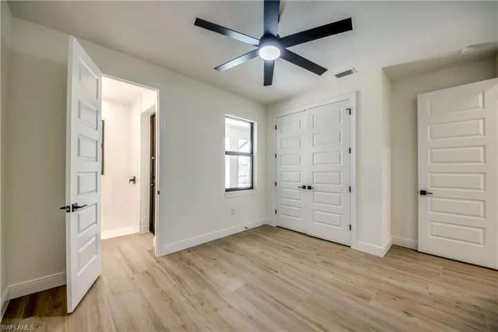 Unfurnished bedroom featuring light wood-style flooring, a closet, and ceiling fan