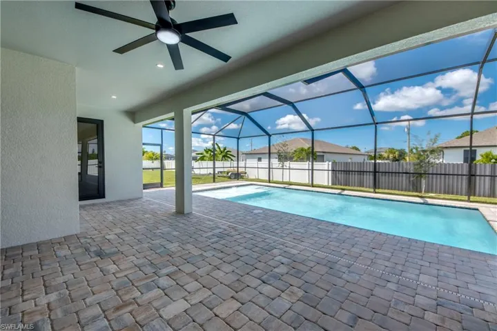 View of pool featuring a patio area, a sunroom, a lanai, a ceiling fan, and a residential view