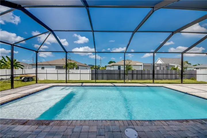 View of pool with a sunroom, a fenced backyard, and a lanai