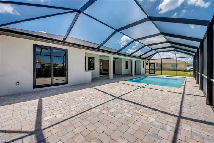 Outdoor pool with a sunroom, a patio area, ceiling fan, and a lanai