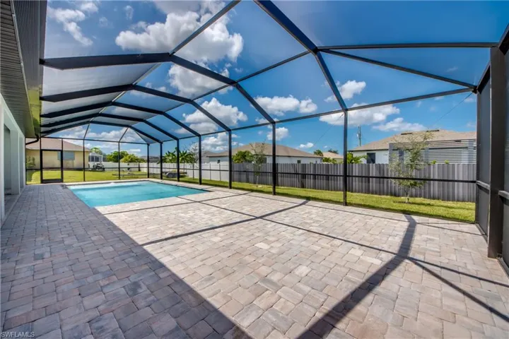Outdoor pool with a sunroom, a patio, and glass enclosure