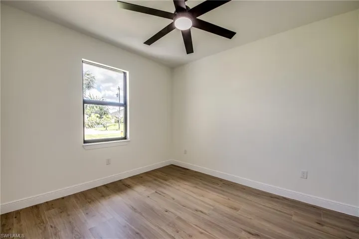 Spare room with light wood finished floors and ceiling fan
