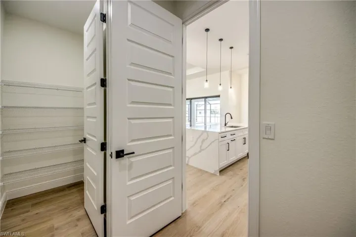 Corridor featuring light wood-style floors and a textured wall