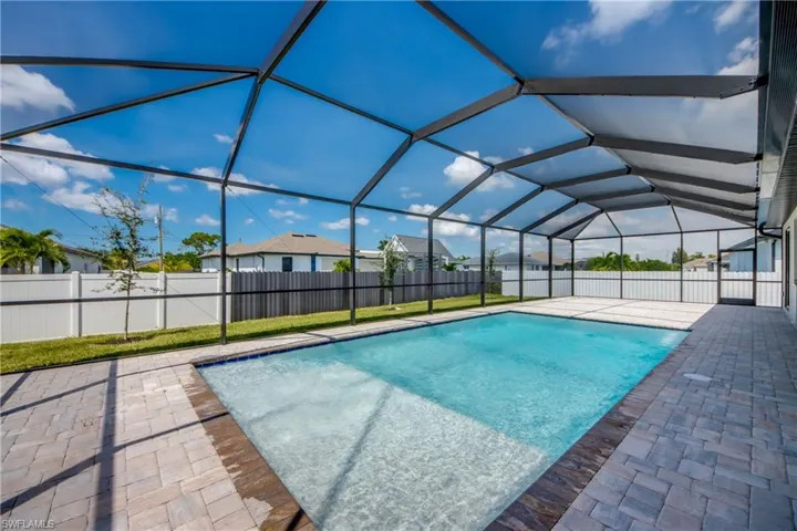 View of swimming pool featuring a fenced backyard, a sunroom, a patio area, and a lanai
