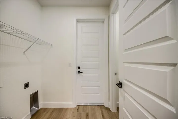 Laundry area featuring light wood finished floors and hookup for an electric dryer
