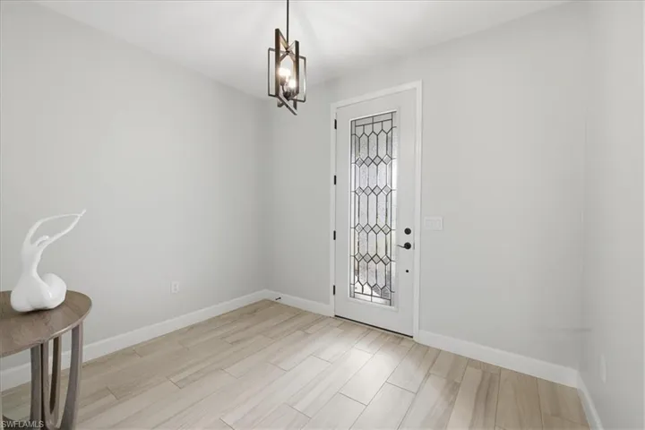 Foyer with hanging lights and wood finish floors
