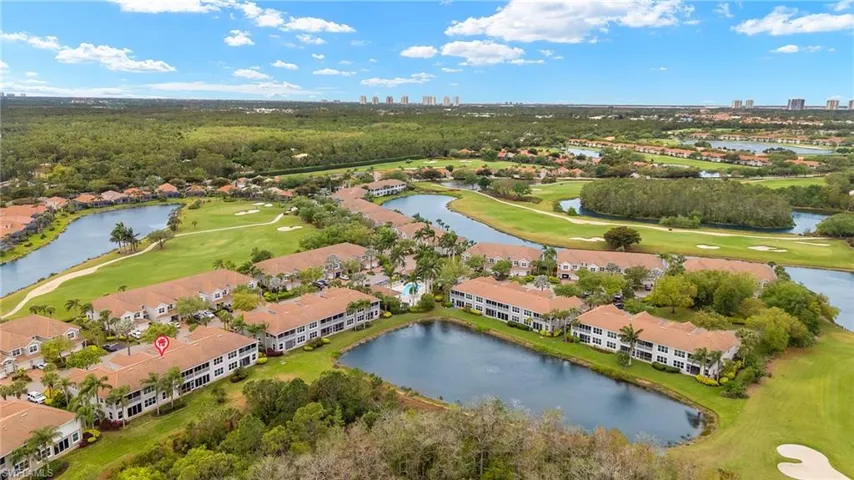 Birds eye view of property with a water view and view of golf course